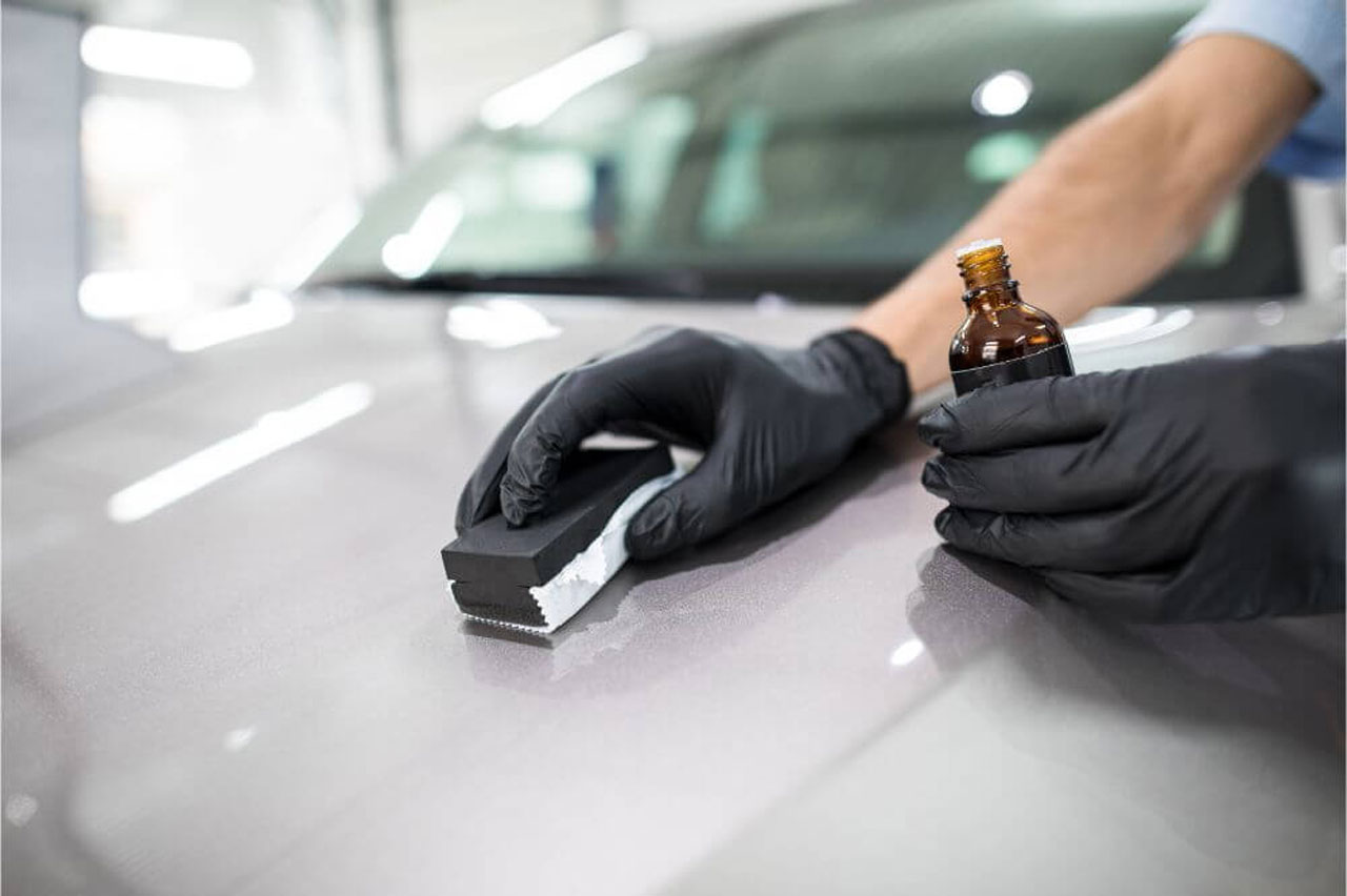 A professional detailer installing ceramic paint coatings on a car