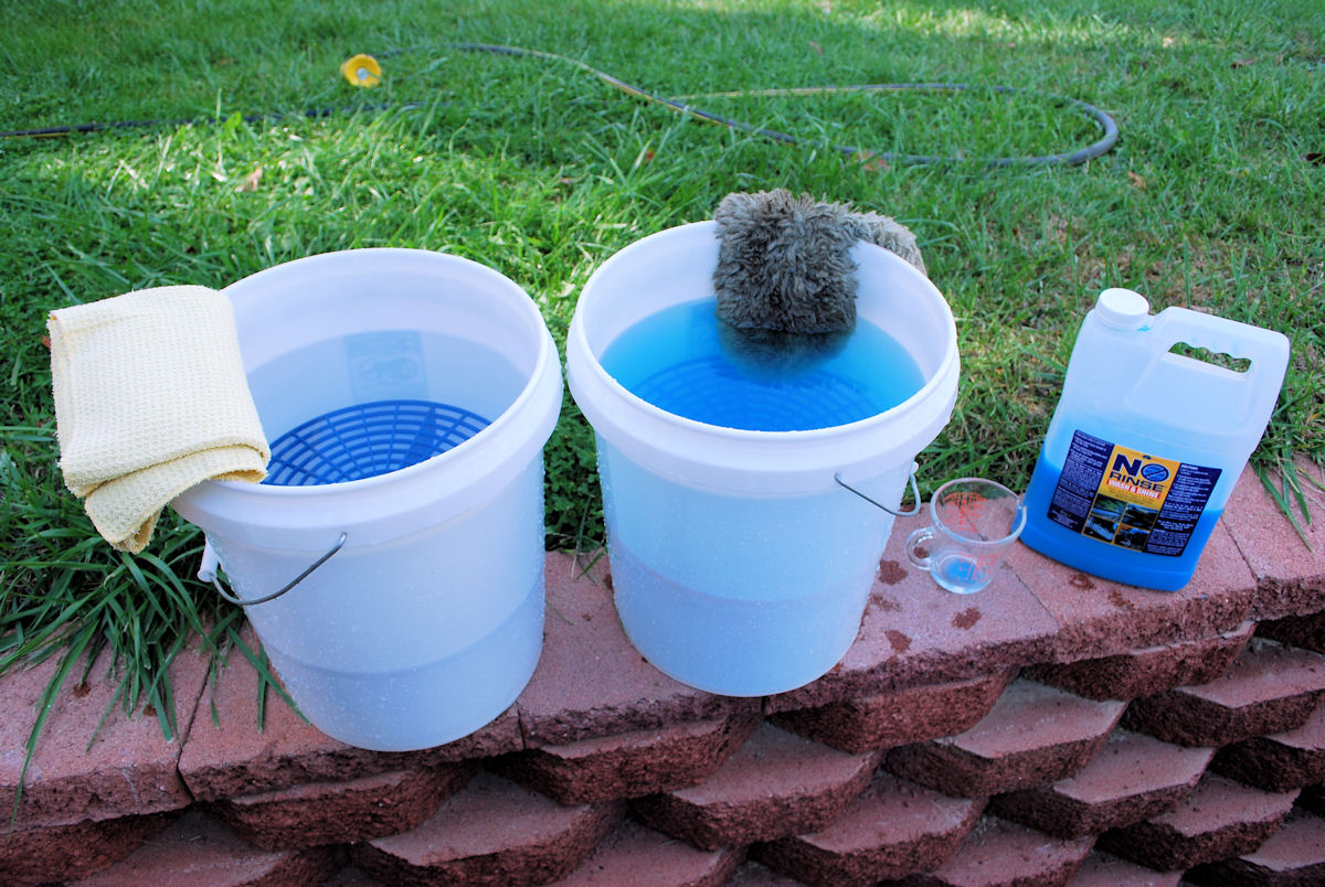 Two car washing buckets with waterless car wash soap and water.